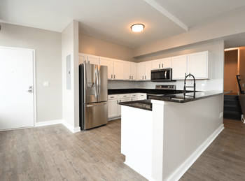 a kitchen with white cabinets and stainless steel appliances